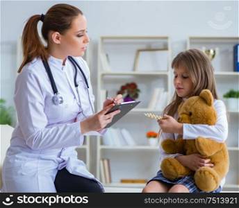 Woman female doctor examining little cute girl with toy bear. The woman female doctor examining little cute girl with toy bear