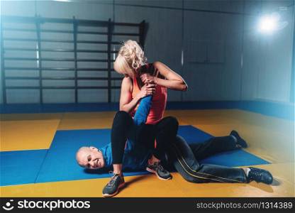 Woman fights with man, self-defense technique, self defense workout in gym, martial art