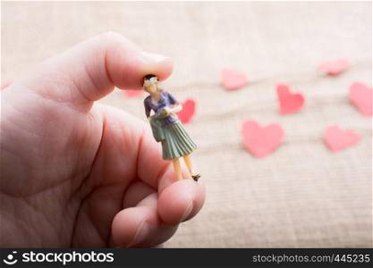 Woman figurine and Love concept with paper heart on threads