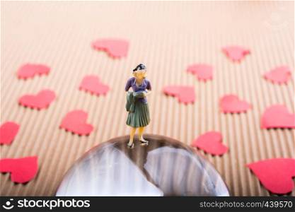 Woman figurine and Love concept with red paper hearts