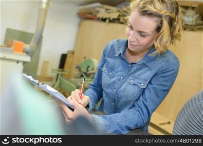 woman filling a form clipped to pad
