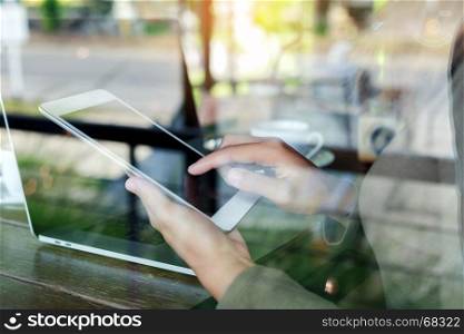 woman finger touching on digital tablet see through glass in coffee shop