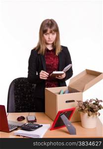 Woman fired from her job at the office and collect personal belongings in a box with a sad view. Dismissed girl puts personal belongings in office