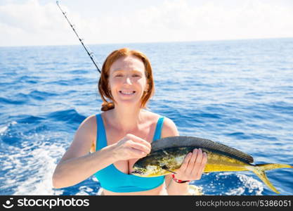 Woman fishing Dorado Mahi-mahi fish happy with trolling catch on boat deck