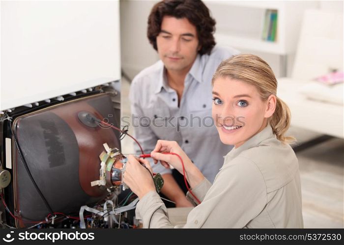 Woman fixing a television set