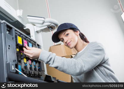 woman fixing cartridge in printer machine at office