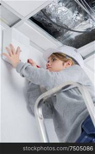 woman fixing ceiling at home