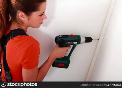 woman fixing something on a wall
