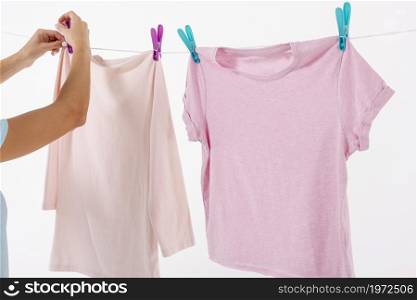 woman fixing t shirts clothesline with clothes pins. High resolution photo. woman fixing t shirts clothesline with clothes pins. High quality photo