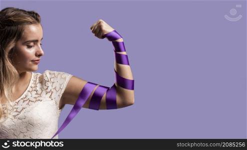 woman flexing her arm with ribbon copy space