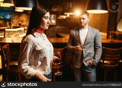 Woman flirting against man, couple in bar. Lovers leisures in pub, husband and wife relaxing together in nightclub