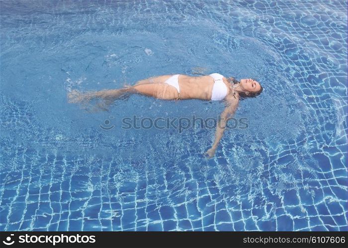 Woman floating in pool. Woman floating and relaxing in swimming pool water