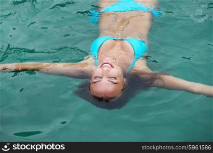 Woman floating in sea. Woman floating and relaxing in blue water of sea in Thailand