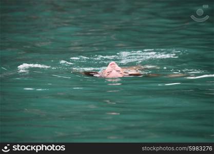 Woman floating in sea. Woman floating and relaxing in blue water of sea in Thailand