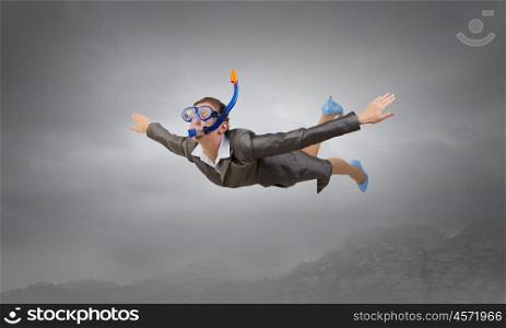 Woman floating in sky. Young businesswoman in suit and diving mask flying in sky