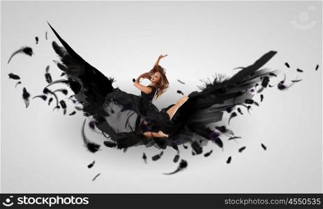 Woman floating on dark wings. Woman floating in a dance on dark wings. Collage.