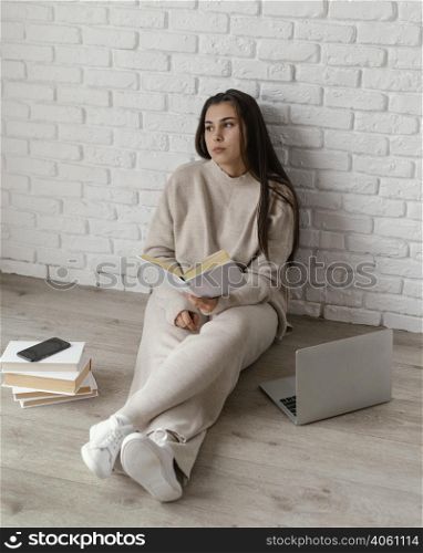 woman floor with book laptop