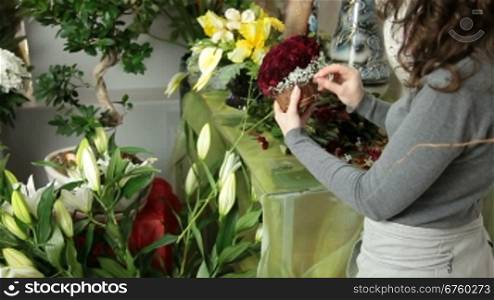 Woman Florist Creating Red Roses Bouquet Arranged in Heart Shape In Flower Shop