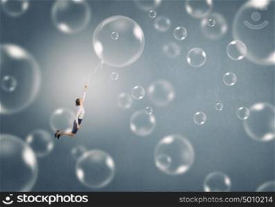Woman fly in sky. Young businesswoman flying high in sky on soap bubble