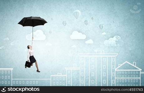 Woman fly on umbrella. Young businesswoman flying high in sky on black umbrella