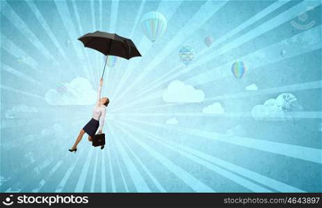 Woman fly on umbrella. Young businesswoman flying high in sky on black umbrella