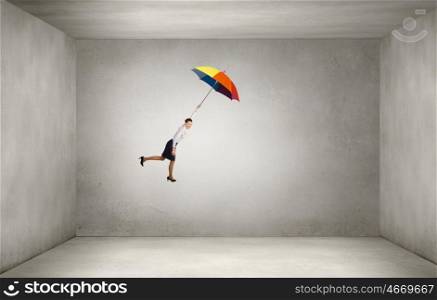 Woman fly on umbrella. Young businesswoman flying high in sky on umbrella