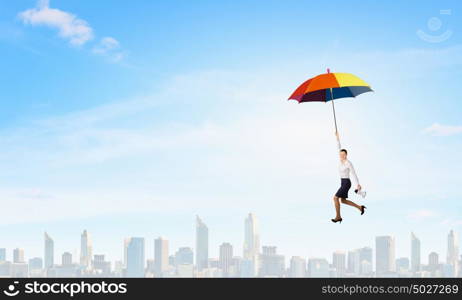 Woman fly on umbrella. Young businesswoman flying high in sky on umbrella