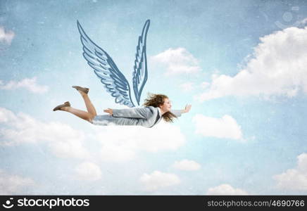 Woman flying high. Young businesswoman with drawn wings flying high in sky