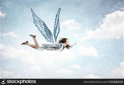 Woman flying high. Young businesswoman with drawn wings flying high in sky