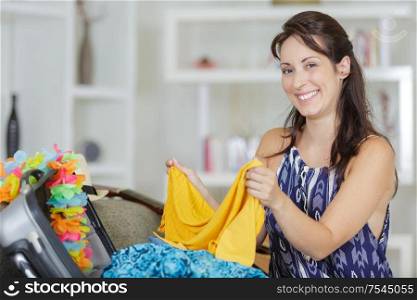 woman folding her clothes to be put in suitcase