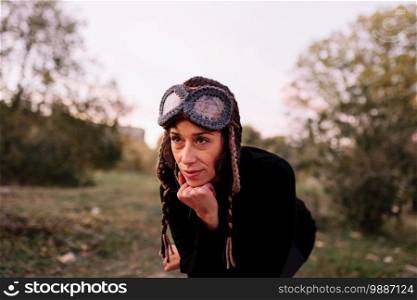 Woman fooling around on a park bench with a wood helmet. Woman fooling around on a park bench
