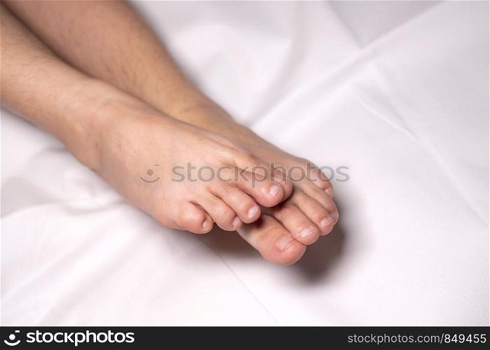 Woman foot flexion on bed sheets color white
