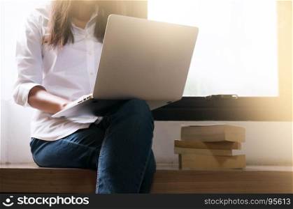woman freelancer is working on a new project on laptop computer hipster girl keyboarding on net-book while relaxing at home.