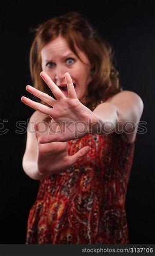 Woman gesturing stop sign. Focus on arm.