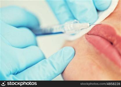 woman gets injection in her lips. Closeup of woman gets injection in her lips
