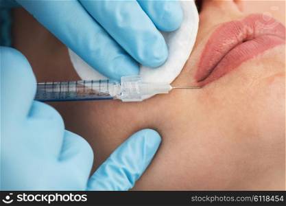 woman gets injection in her lips. Closeup of woman gets injection in her lips