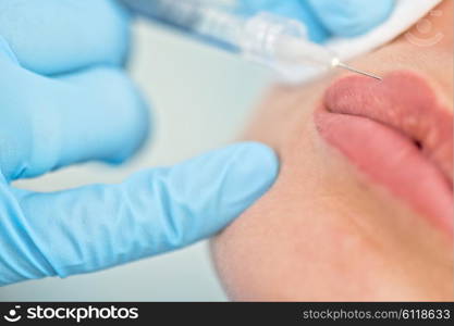 woman gets injection in her lips. Closeup of woman gets injection in her lips