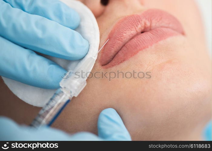 woman gets injection in her lips. Closeup of woman gets injection in her lips