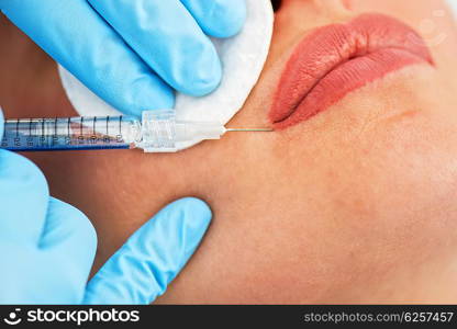 woman gets injection in her lips. Closeup of woman gets injection in her lips