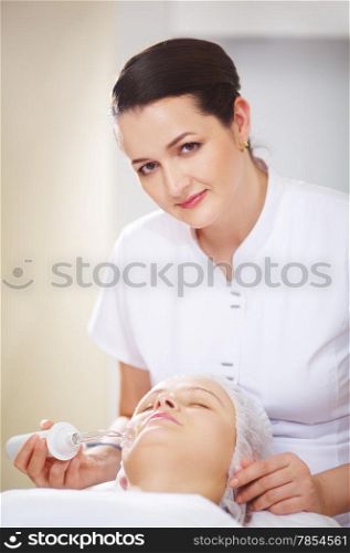 Woman getting anti-aging treatment from professional cosmetician