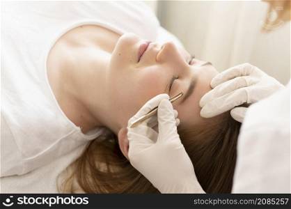 woman getting eyebrow treatment