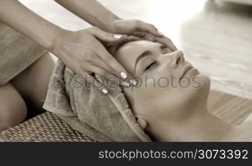 Woman getting facial massage in spa