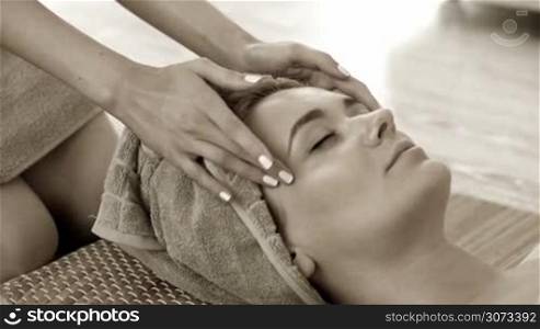 Woman getting facial massage in spa