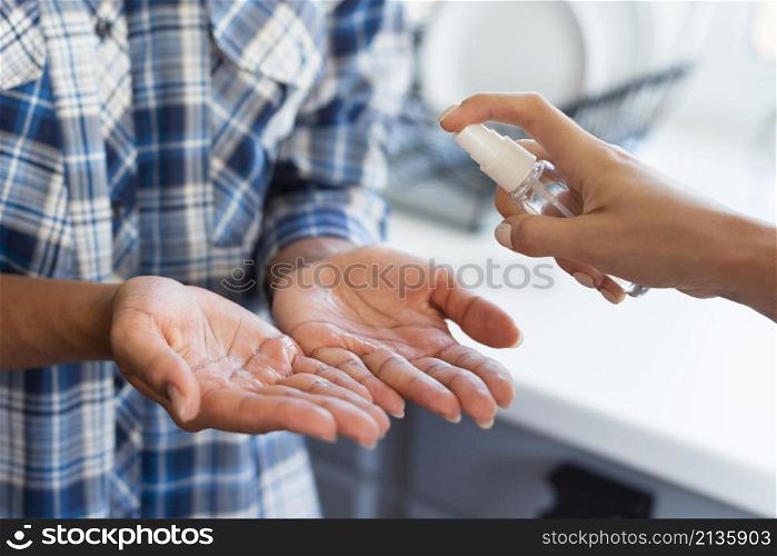 woman getting help with hand sanitizer from friend