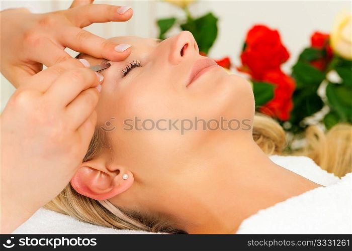 woman getting her eyebrows plucked