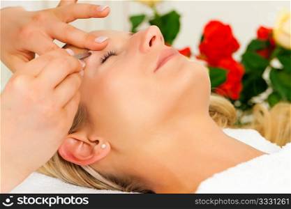 woman getting her eyebrows plucked