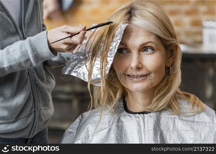 woman getting her hair dyed by hairdresser home