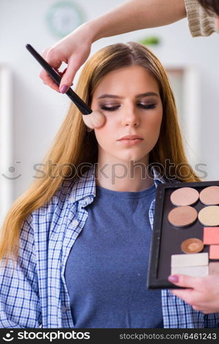 Woman getting her make-up done in beauty salon