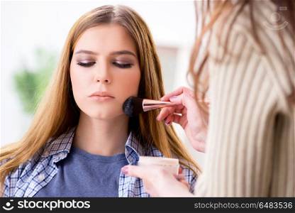 Woman getting her make-up done in beauty salon
