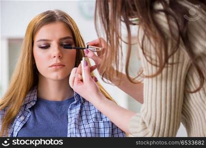 Woman getting her make-up done in beauty salon